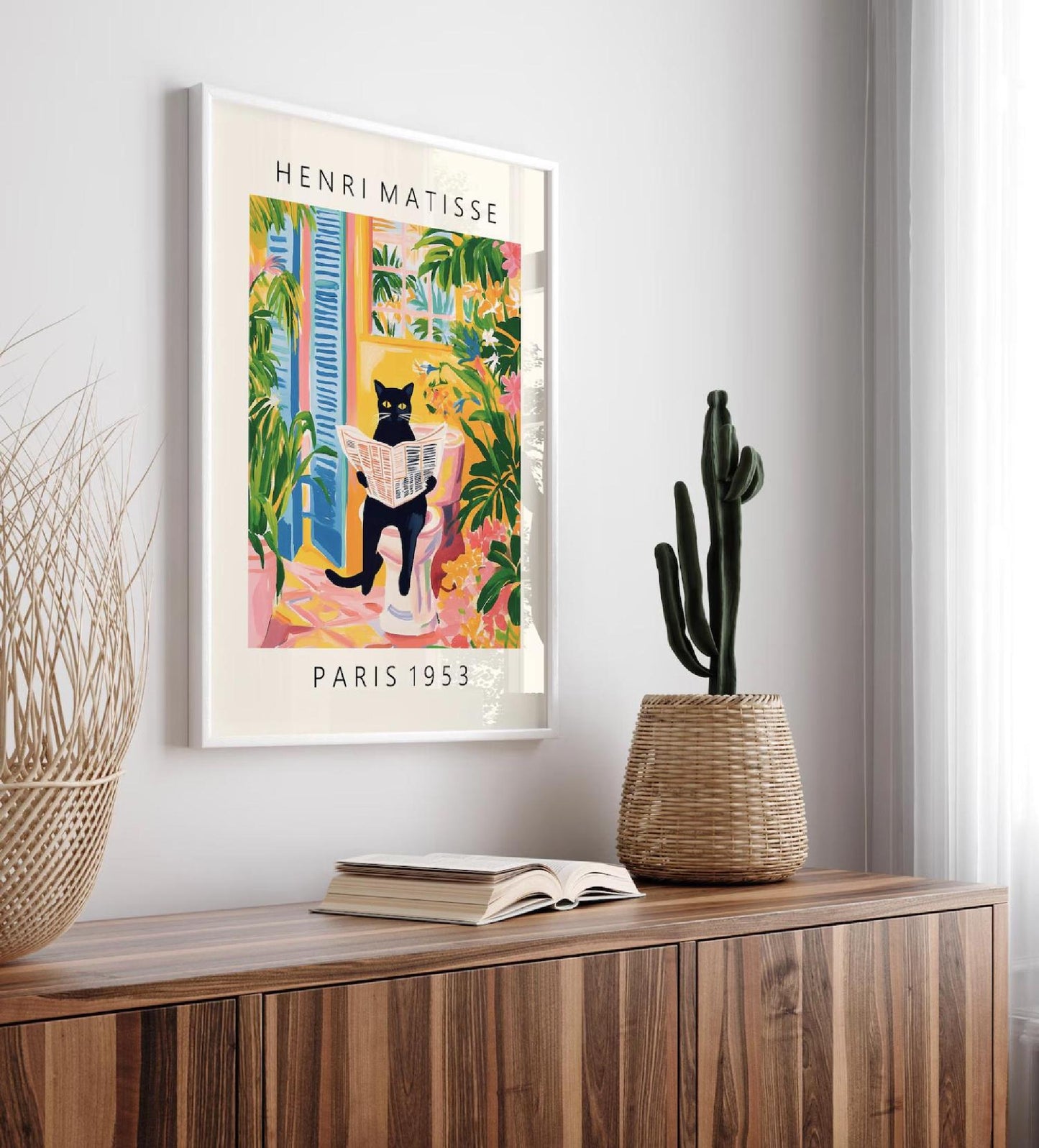 Framed Henri Matisse art print on a wall above a wooden cabinet with decorative items.