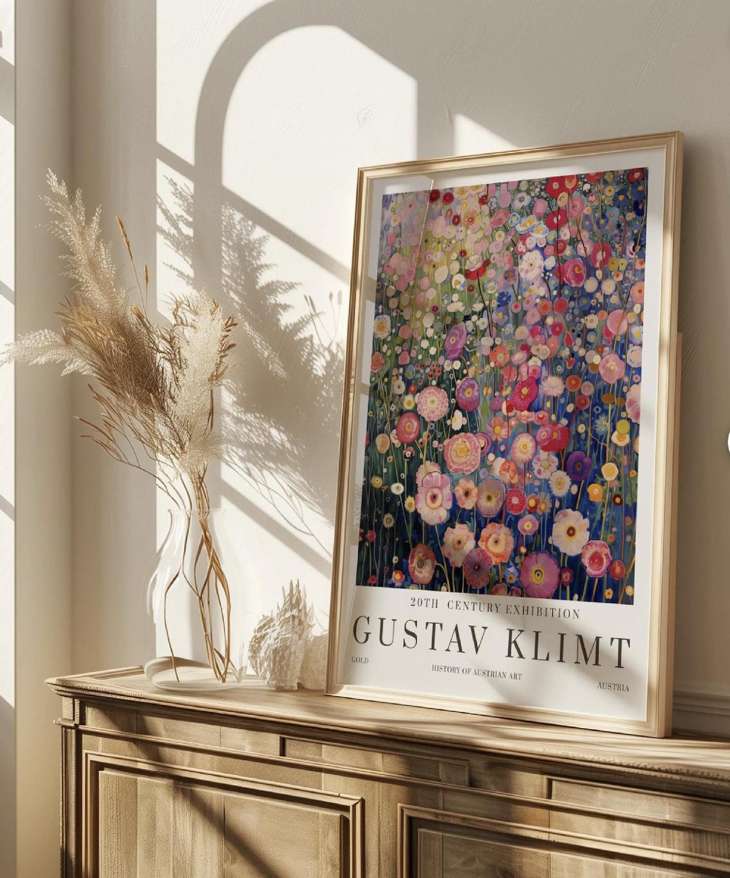 A promotional poster for an art exhibition features a vibrant and highly detailed painting of a dense field of flowers, rendered in the distinctive style of Gustav Klimt. The artwork, which dominates the upper portion of the poster, is a tapestry of various blossoms in shades of pink, red, white, yellow, and purple, set against a backdrop of deep blues and greens that suggest a distant landscape or sky.