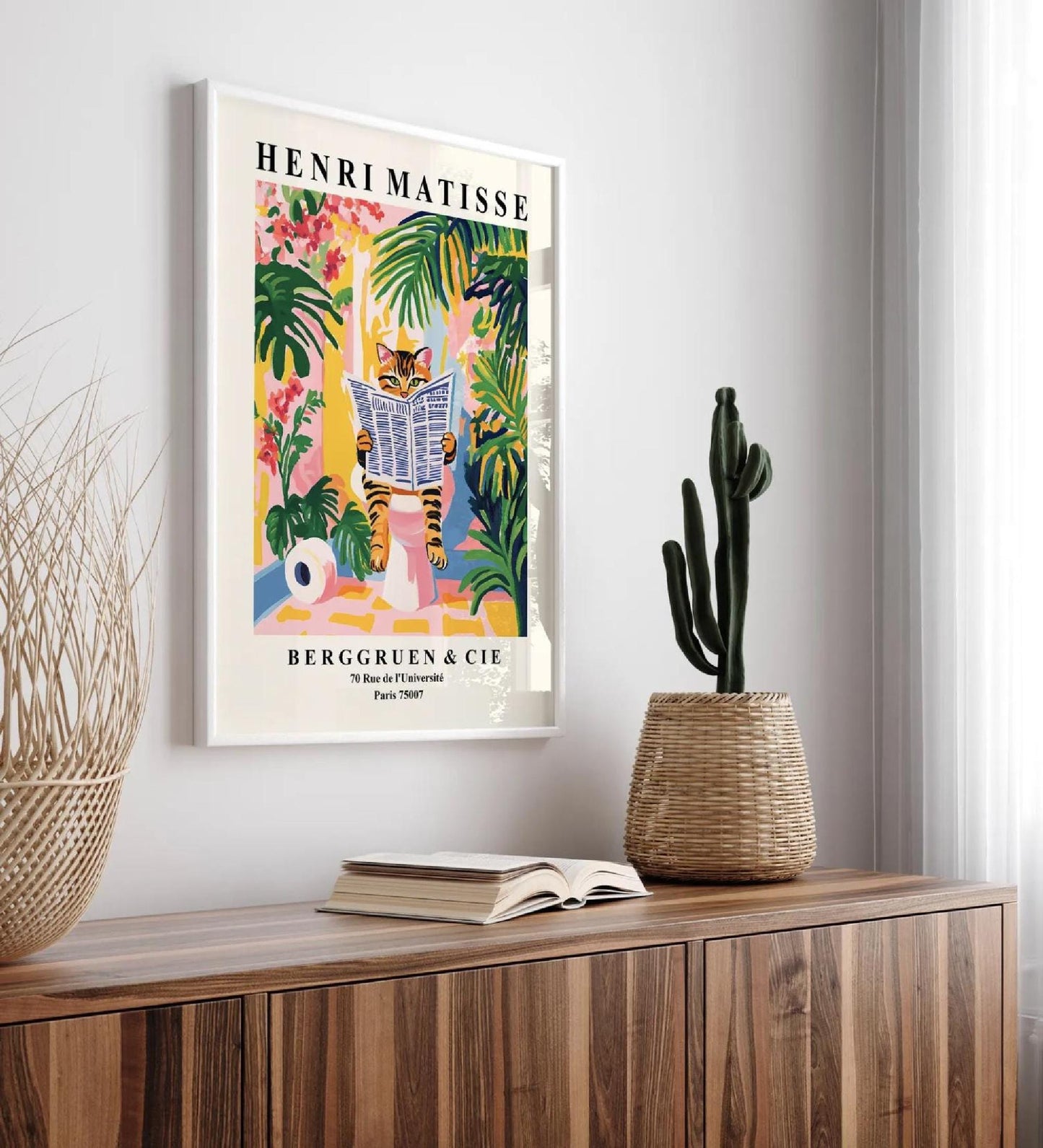 Framed Henri Matisse art print of a tabby cat reading a newspaper in a tropical setting.