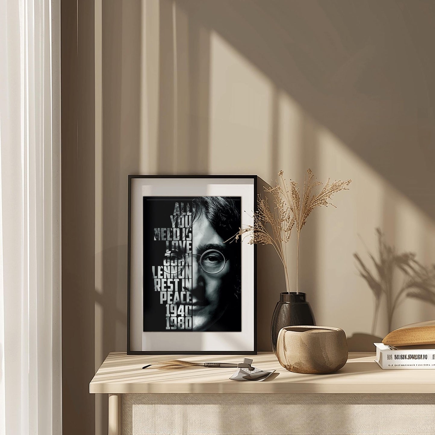 A striking physical poster print featuring a high-contrast black and white portrait of John Lennon, with the text 'ALL YOU NEED IS LOVE' and other meaningful phrases integrated into the design