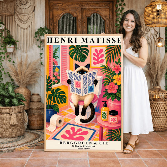 A vertical maximalist art print designed as a Henri Matisse exhibition poster. A cream-colored Siamese cat with dark brown points and blue eyes sits on a toilet, holding and reading a newspaper. The bathroom is vibrantly colored with pink walls, yellow and pink checkered tiles, and lush green monstera plants. A window with pink shutters looks out onto a blue sea. A pink bath mat with a leaf cut-out design and colorful soap jars add to the eclectic decor.