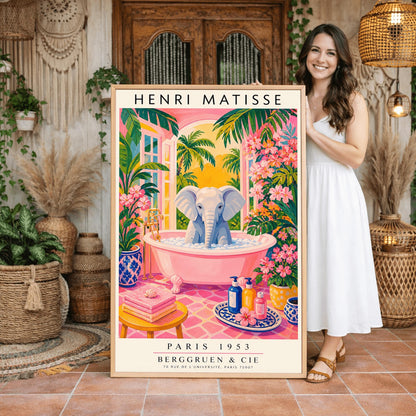A vertical maximalist art print styled as a Henri Matisse exhibition poster. A light grey baby elephant is sitting in a large pink clawfoot bathtub filled with white bubbles. The bathroom features hot pink tiled floors, vibrant pink flowers, and lush green tropical plants. In the background, an arched window shows a bright golden sunset with palm tree silhouettes. A small yellow stool with towels and various blue and yellow ceramic vases decorate the room.