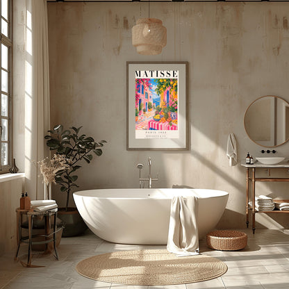 A vertical maximalist art print styled as a Henri Matisse exhibition poster. The scene depicts a vibrant, colorful street in a Mediterranean coastal town. In the foreground, a table with a pink and white striped cloth is piled high with lemons, oranges, and a pineapple. Hot pink and yellow buildings with blue shutters line a cobblestone path that leads toward a blue sea under a bright sky. Lush green trees with yellow lemons and pink flowers frame the view.