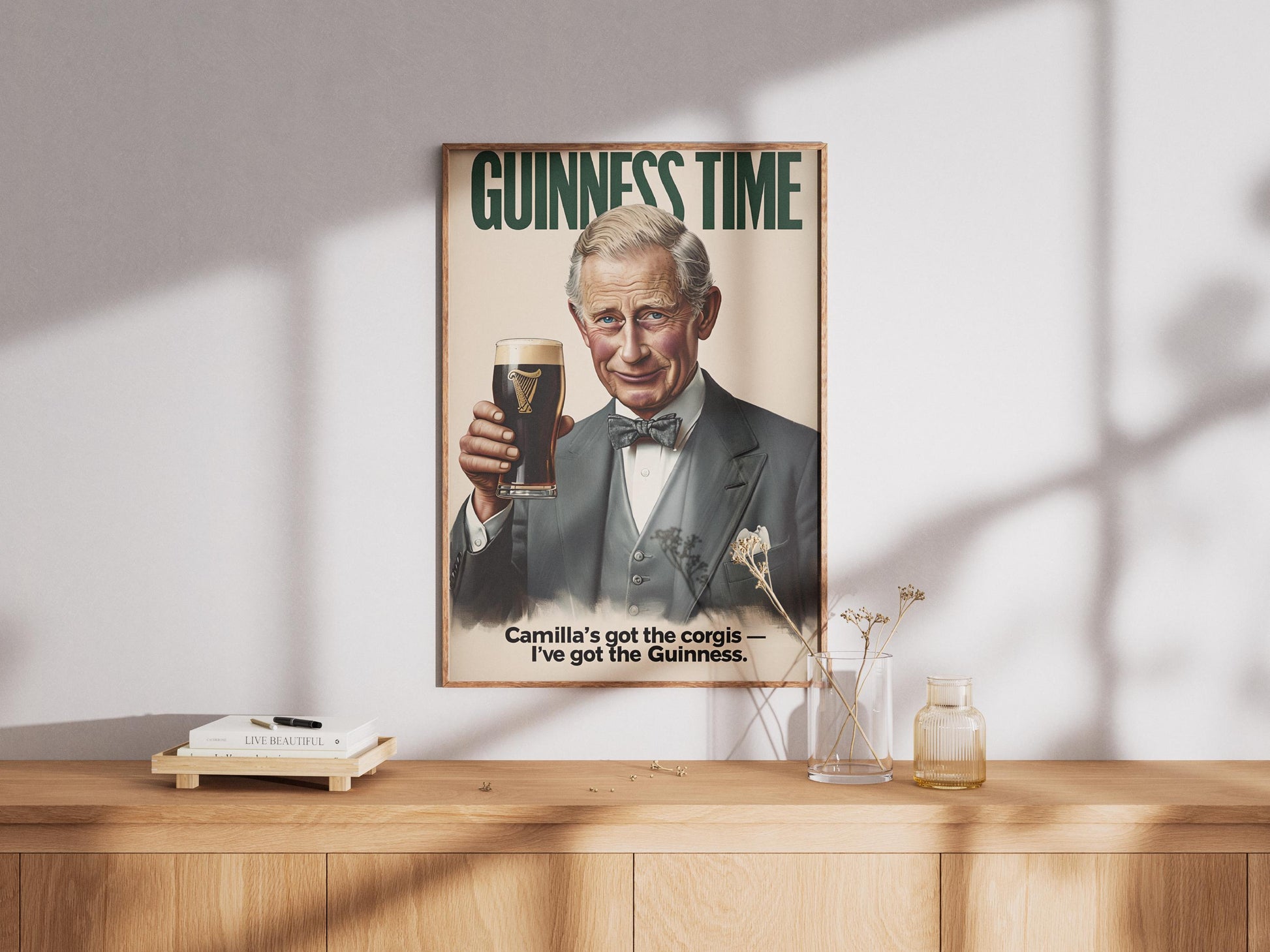 A humorous art print featuring King Charles III holding a classic pint of Guinness. The illustration shows him smiling with the iconic dark stout and creamy head. The text 'GUINNESS TIME' appears at the top, and 'Camilla's got the corgis — I've got the Guinness.' at the bottom, adding a witty royal touch. This unique print is ideal for pub or bar decor, a man cave, or as a quirky gift for fans of the British Royal Family and Guinness beer, blending humor with an iconic beverage