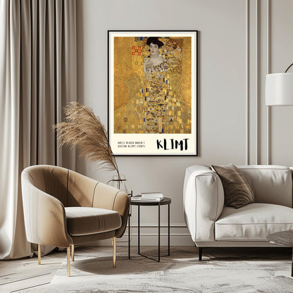 A vertical museum exhibition poster of Gustav Klimt's 1907 "Portrait of Adele Bloch-Bauer I." A woman is shown encased in a lavish gold dress with eye and triangle patterns against a shimmering gold mosaic background. The bottom border is cream with bold black text reading "ADELE BLOCH-BAUER I" and "KLIMT."