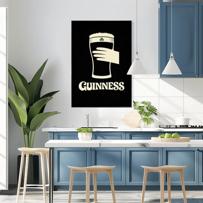 A vertical minimalist graphic design on a textured black background. A cream-colored hand is shown holding a pint of Guinness stout, with the glass itself created out of negative space. A small green shamrock is on the foam. The word "GUINNESS" is in cream text at the bottom.