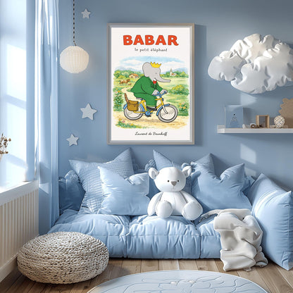 A vertical children's illustration poster titled "BABAR le petit éléphant" at the top in red. King Babar, in a green suit and crown, is riding a yellow bicycle along a dirt path. A brown leather bag on the back of the bike holds a baguette. The background shows a green meadow with a cow and calf, small bushes with flowers, and a distant house and church under a soft sky. The name "Laurent de Brunhoff" is at the bottom.