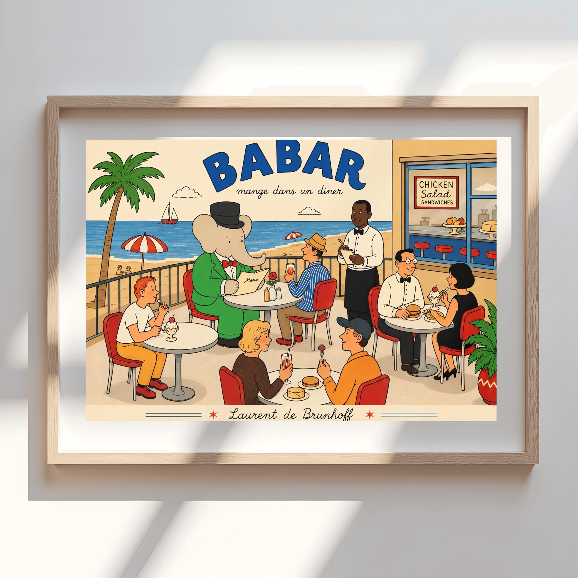 A bright 1950s-style illustration poster titled "BABAR mange dans un diner" in bold blue and black script. The scene shows an outdoor diner balcony overlooking a sandy beach and blue ocean with a sailboat. On the left, the cartoon elephant King Babar sits at a round white table in a green suit and top hat, reading a menu. Several other patrons are seated at tables on red chairs eating burgers and ice cream sundaes, while a waiter in a bowtie takes notes.