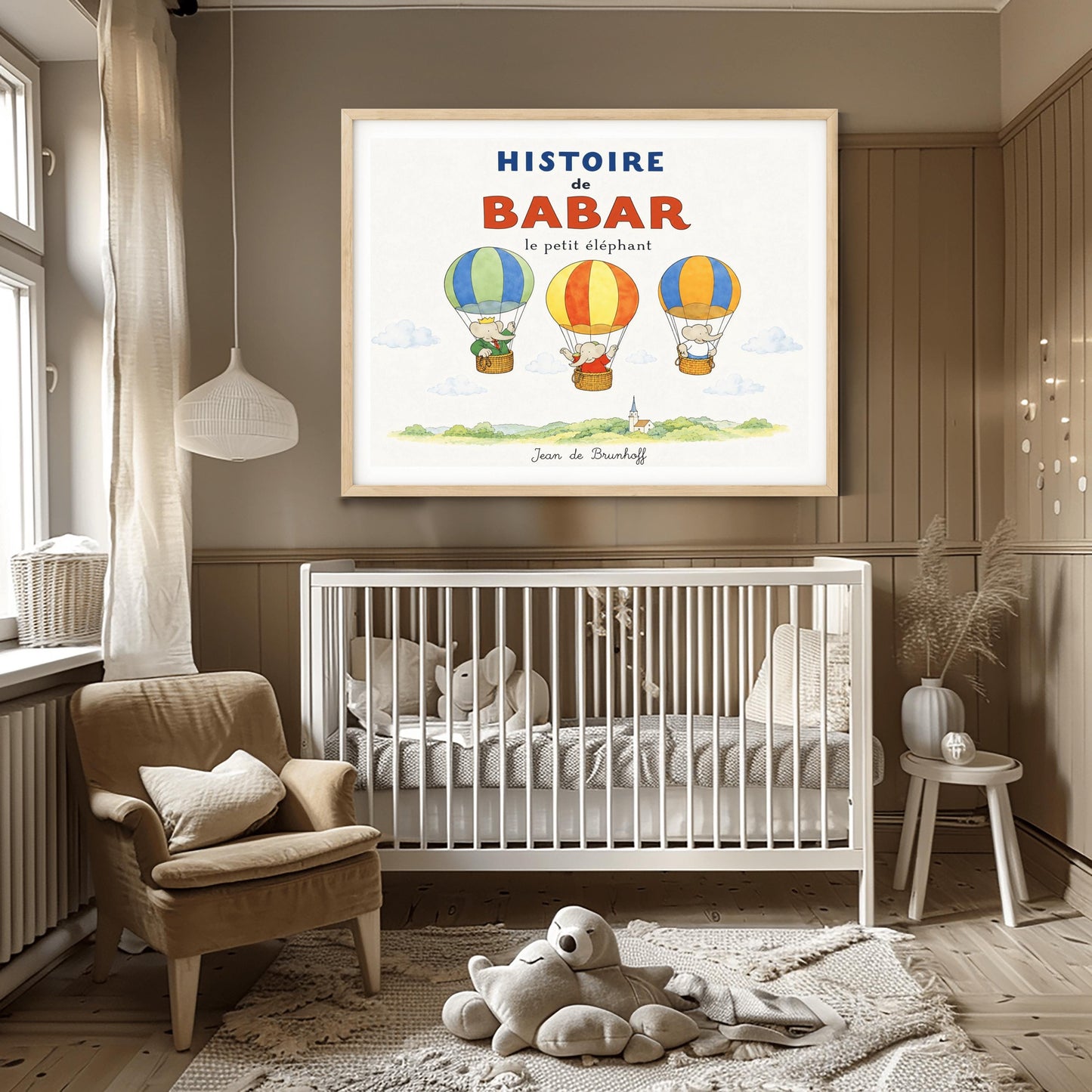 A whimsical vintage-style storybook poster on a clean white background titled "HISTOIRE de BABAR le petit éléphant" in bold blue and orange lettering. The illustration features three cartoon elephants floating in striped hot air balloons over a light green watercolor countryside with a white church steeple. On the left, King Babar in a green suit and crown waves from a blue-and-green balloon. In the center, an elephant in a red dress sits in a yellow-and-orange balloon.