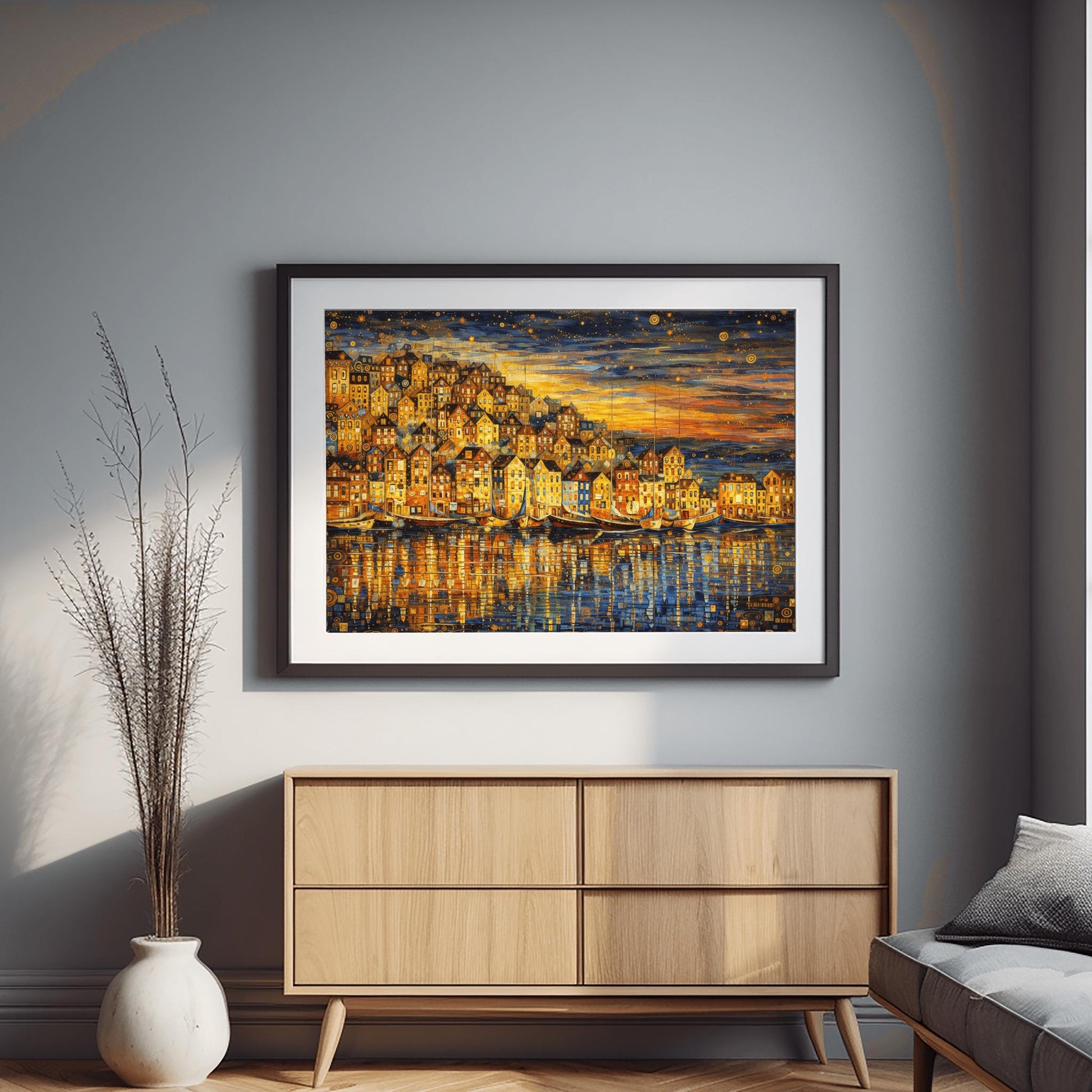 A horizontal landscape art print in the style of Gustav Klimt, depicting a coastal village at dusk. A dense cluster of golden, mosaic-patterned houses sits on a hill overlooking a harbor. Several traditional wooden sailboats are anchored in the water, which reflects the warm gold light of the buildings. The sky above is a dark indigo filled with golden swirling patterns and stylized stars. The overall composition is rich with gold leaf textures and intricate decorative details.