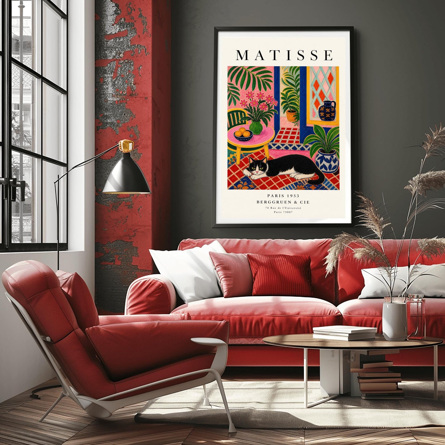 A vertical maximalist art print styled as a Henri Matisse exhibition poster. A black and white tuxedo cat lies across an intricate red, orange, and blue patterned rug. The room features textured bubblegum pink walls and a cobalt blue door frame. To the left, a pink table holds a bowl of oranges and a green vase with pink flowers. To the right, a blue and white floral pot holds a green plant. A diamond-patterned window is visible in the background.