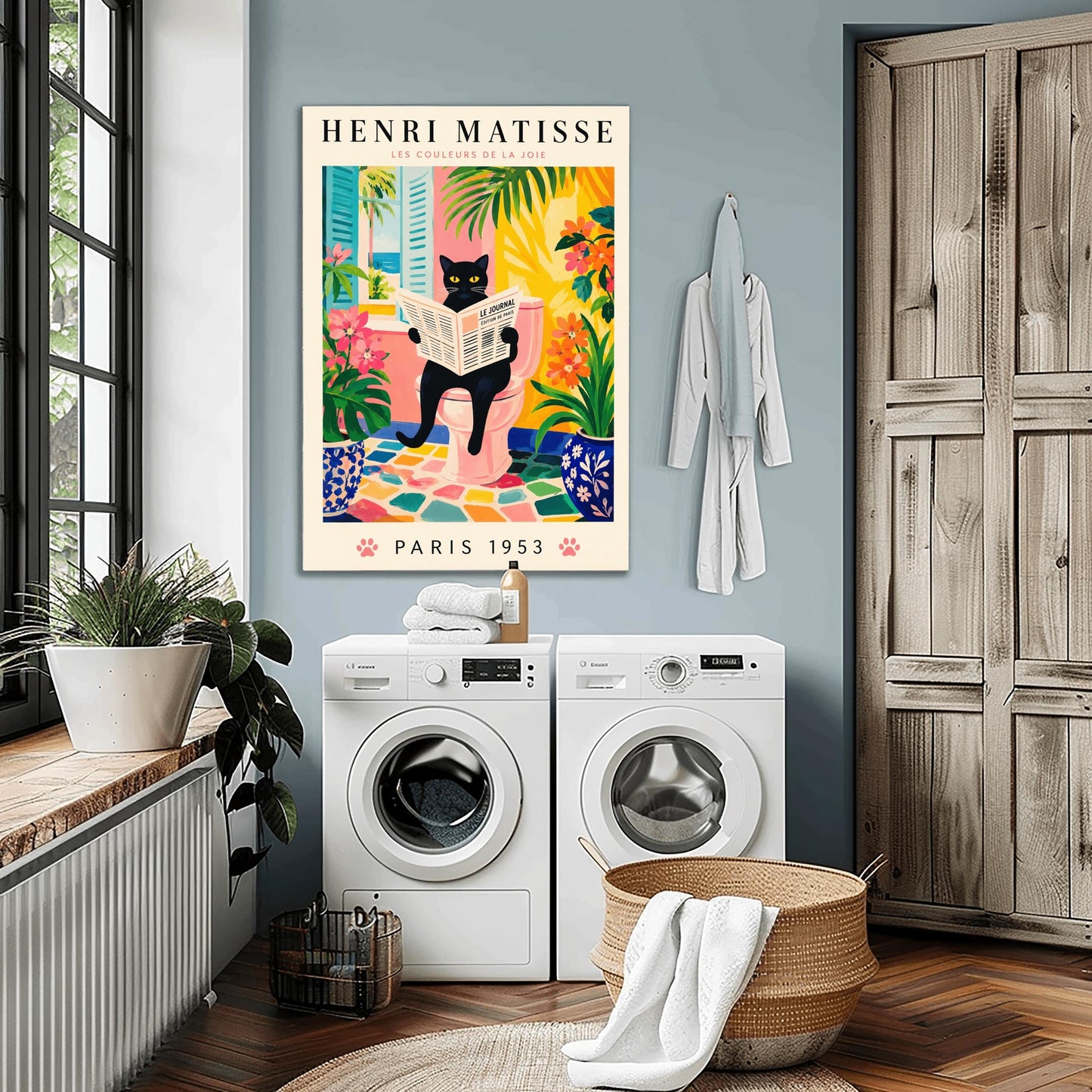 A vertical gallery poster on a cream background titled "HENRI MATISSE - LES COULEURS DE LA JOIE" in black and pink font. The central image shows a sleek black cat with bright yellow eyes sitting on a pastel pink toilet, reading a French newspaper titled "LE JOURNAL". The bathroom features an open window with blue shutters looking out at a beach, ocean, and palm trees. The room is decorated with lush green plants, potted orange flowers, and a colorful mosaic stone floor.