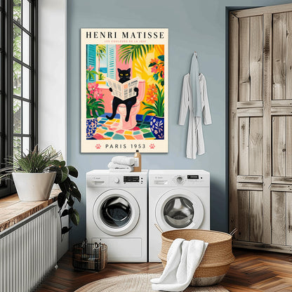 A vertical gallery poster on a cream background titled "HENRI MATISSE - LES COULEURS DE LA JOIE" in black and pink font. The central image shows a sleek black cat with bright yellow eyes sitting on a pastel pink toilet, reading a French newspaper titled "LE JOURNAL". The bathroom features an open window with blue shutters looking out at a beach, ocean, and palm trees. The room is decorated with lush green plants, potted orange flowers, and a colorful mosaic stone floor.