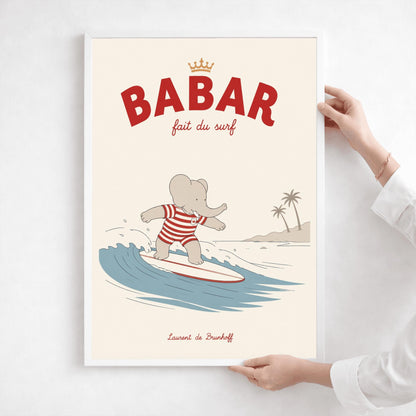 A vertical storybook-style art print of Babar the Elephant surfing. Babar is wearing a red and white striped swimsuit and standing on a white surfboard with a red stripe. He is riding a blue wave with a white crest. In the background, there is a tan beach with two palm trees under a cream sky. The top reads "BABAR fait du surf" with a small gold crown.