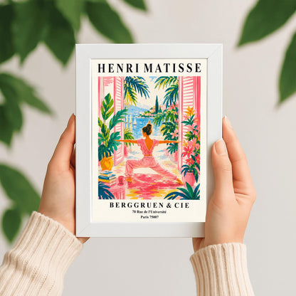 A vertical museum-style exhibition poster with a cream border featuring text for an Henri Matisse exhibition at Berggruen & Cie in Paris,. The colorful central illustration depicts a woman from behind practicing a yoga pose on a pink mat on a terrace. She is framed by open pink shutters and lush green potted plants. Through the open doors is a scenic view of a bright blue sea with sailboats, a coastal hill town, and green palm trees under a sunny sky.