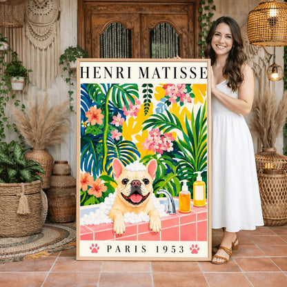 A vertical fine art exhibition poster in the style of Henri Matisse featuring a wide cream border. Bold black text reads "HENRI MATISSE" at the top and "PARIS 1953" at the bottom with two pink paw prints. The colorful painting inside depicts a cream French bulldog sitting in a bubble bath behind a pink tiled ledge, surrounded by a dense backdrop of green and blue tropical leaves, pink flowers, and yellow patterns.