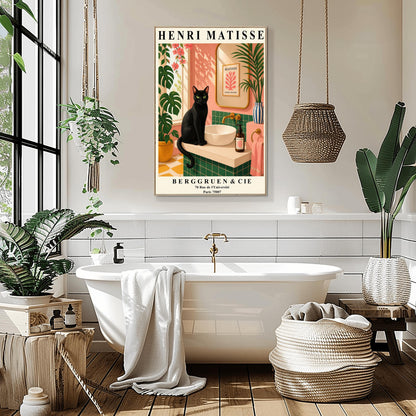 A vertical art print styled as a Henri Matisse exhibition poster. A sleek black cat with bright green eyes sits on a cream-colored bathroom vanity next to a white vessel sink. The bathroom features blush pink walls and emerald green tiles. A gold-framed mirror reflects a Matisse leaf print. Lush green plants and pink flowers frame the scene, and dappled sunlight creates shadows on the wall. The poster has bold black text at the top and bottom with the gallery name Berggruen & Cie.