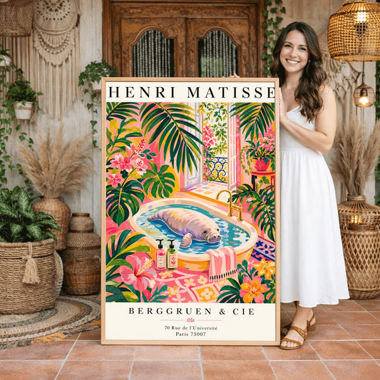 A vertical maximalist art print designed as a Henri Matisse exhibition poster. A large, grey manatee floats peacefully in a white bathtub filled with water. The room is filled with vibrant pink walls, lush green tropical plants, and bright pink hibiscus flowers. An open balcony door in the background shows a Parisian-style wrought-iron railing and pink flowers. Two colorful soap bottles sit on the edge of the tub.