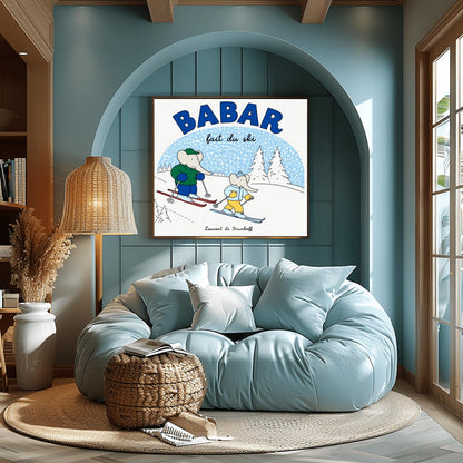 A horizontal children's art print featuring two cartoon elephants skiing down a white hill from left to right. The larger elephant, Babar, is in a green jacket with red skis. The smaller elephant is in a light blue jacket with blue skis. A large blue arch in the background represents a sky filled with white snow. Bold blue text at the top reads "BABAR" and script text below it says "fait du ski." The name "Laurent de Brunhoff" is centered at the bottom.