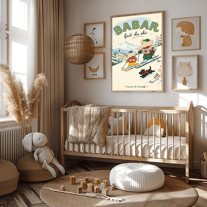 A vertical retro fine art exhibition poster titled "BABAR fait du ski" on a wide cream border. The illustration shows a large elephant and a small elephant skiing down a snowy slope wearing colorful patterned winter sweaters, accompanied by a small black dog in a plaid scarf. A snow-covered village and mountains are visible in the background, with the name "Laurent de Brunhoff" printed at the bottom.