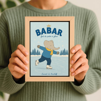 A vertical storybook-style art print featuring Babar the Elephant ice skating on a frozen pond. Babar is wearing a blue sweater, dark pants, a yellow scarf, and white ice skates. He is shown mid-stride with one leg lifted. The background consists of snowy pine trees under a light blue sky with falling snowflakes. The top of the print reads "BABAR fait du patin à glace" with a small gold crown.