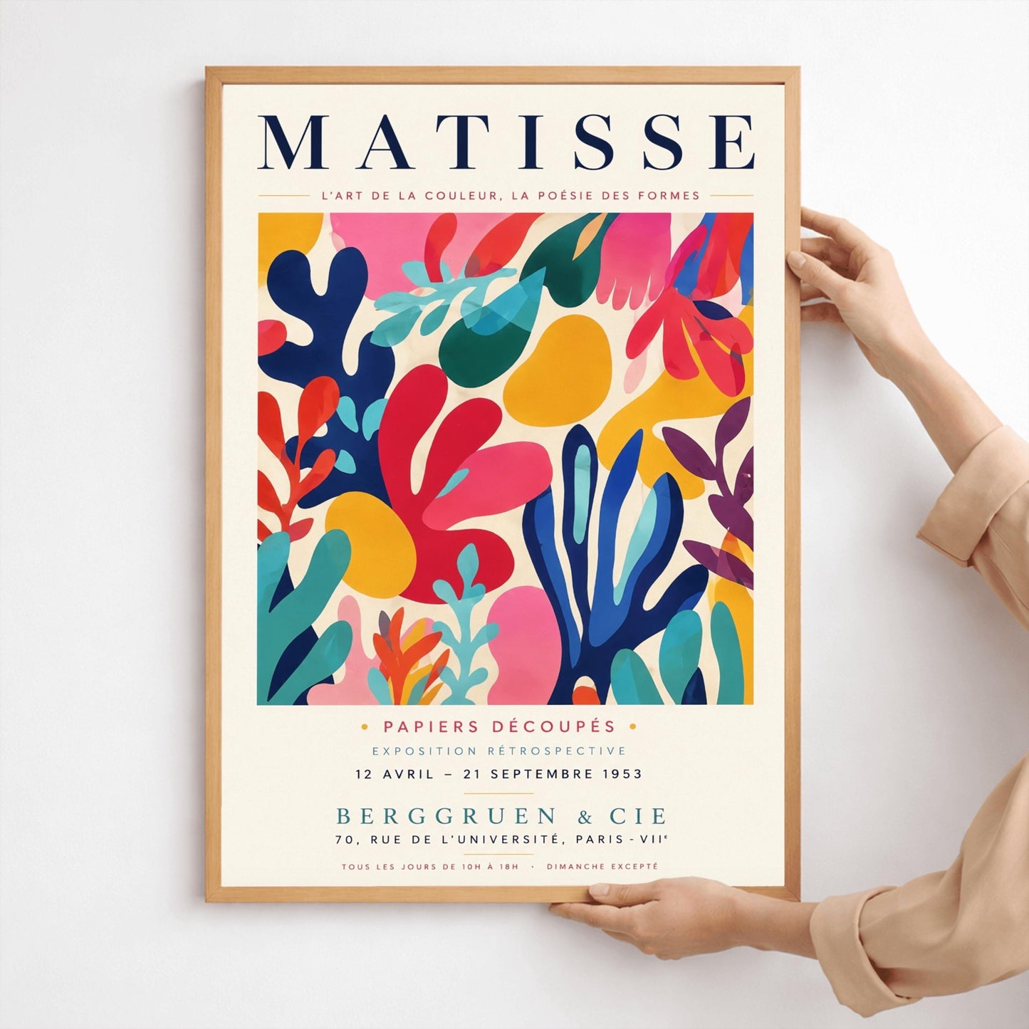 A vertical gallery exhibition poster with a warm cream border. Bold black text at the top reads "HENRI MATISSE". The central artwork is a rectangular block with a solid cobalt blue background, featuring a cream silhouette of an abstract, organic split-leaf design. Below the block, black text reads "PAPIERS DÉCOUPÉS" and "FEUILLE". The bottom of the poster finishes with the text "BERGGRUEN & CIE - 70 RUE DE L'UNIVERSITÉ - PARIS VII".