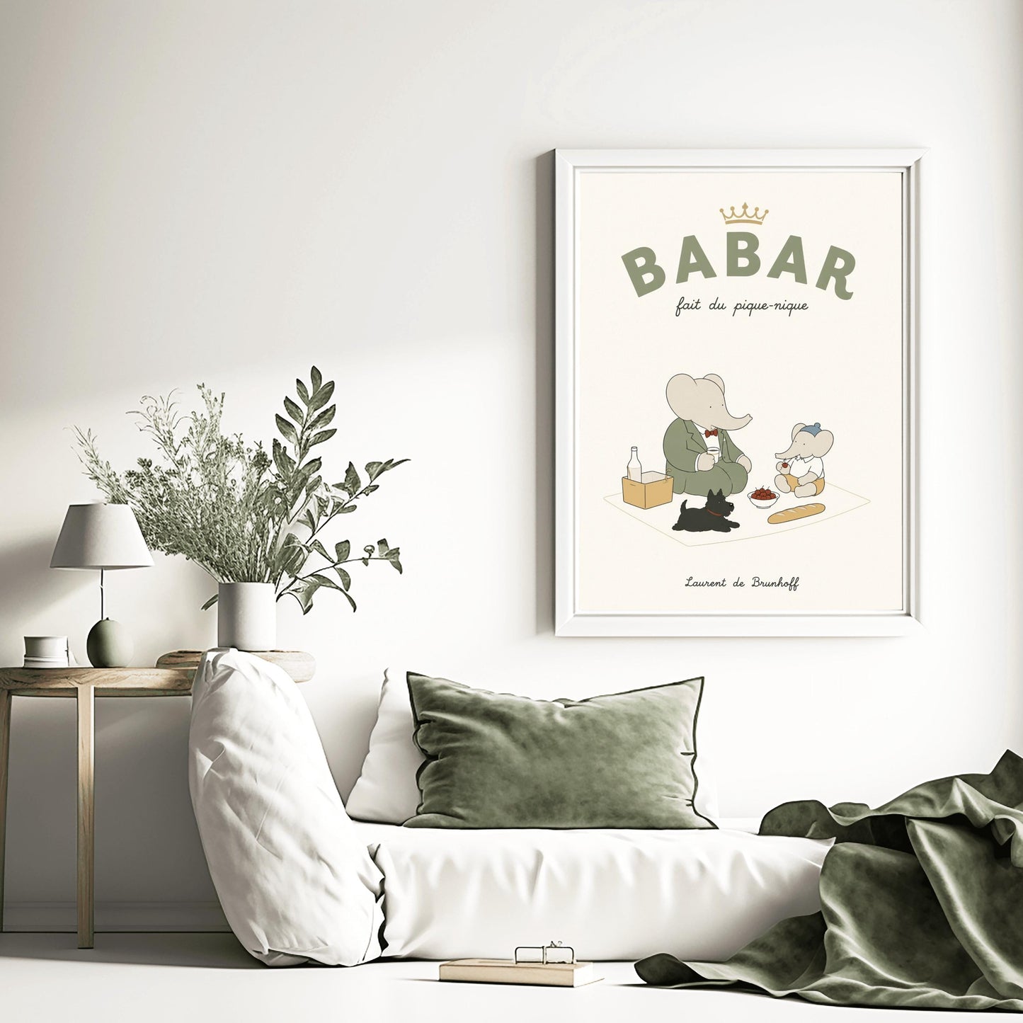 A vertical storybook-style art print of Babar the Elephant having a picnic against a cream background. Babar, in a green suit, sits on a white blanket with a smaller elephant in a blue hat and yellow shorts. A small black dog lies in the foreground. The spread includes a baguette, a bowl of cherries, and a bottle. The top reads "BABAR fait du pique-nique" with a gold crown, and the bottom says "Laurent de Brunhoff."