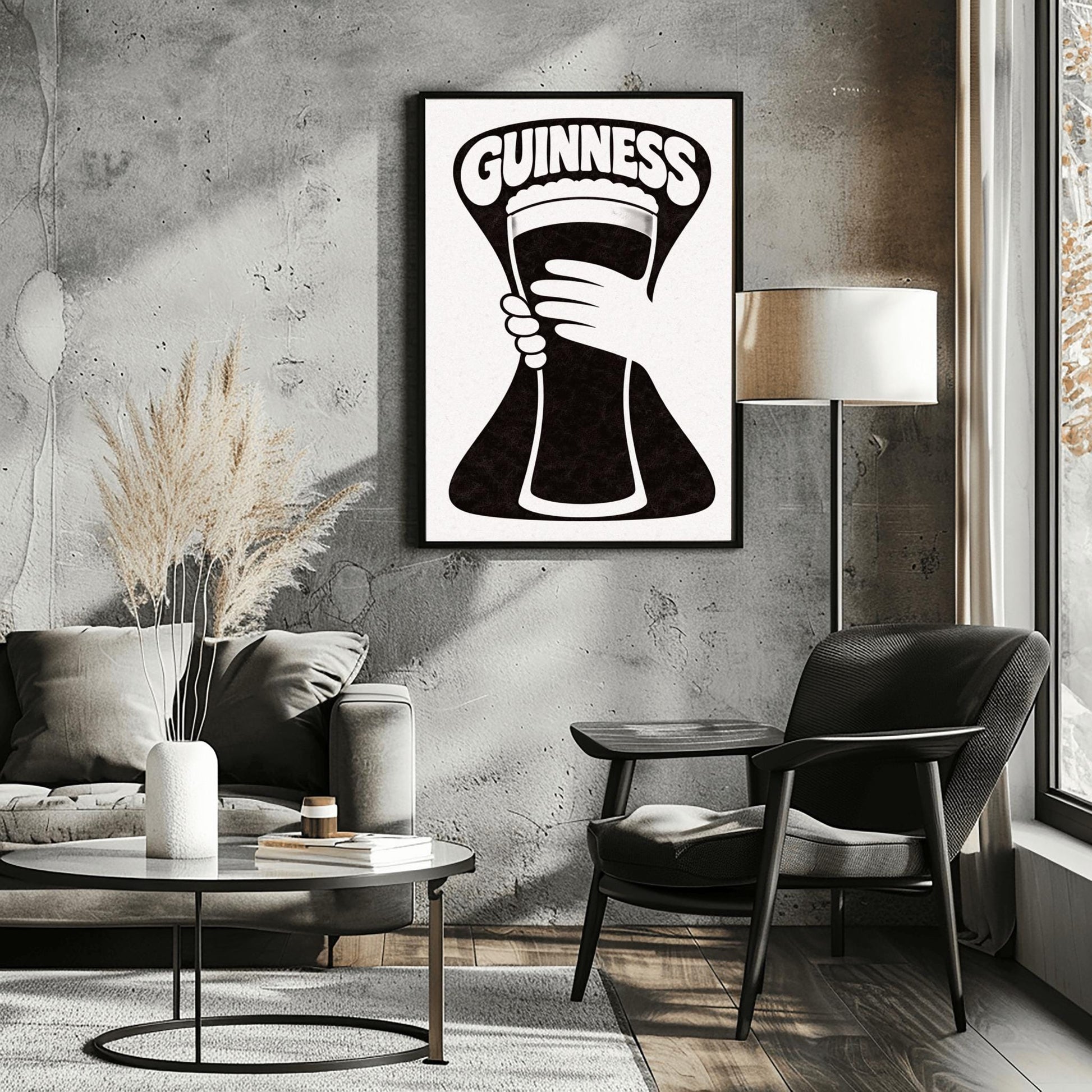 A vertical minimalist graphic in black and white. A large, black hourglass-shaped background features a white hand silhouette holding a pint glass made of negative space. The word "GUINNESS" is arched in bold white text at the top.