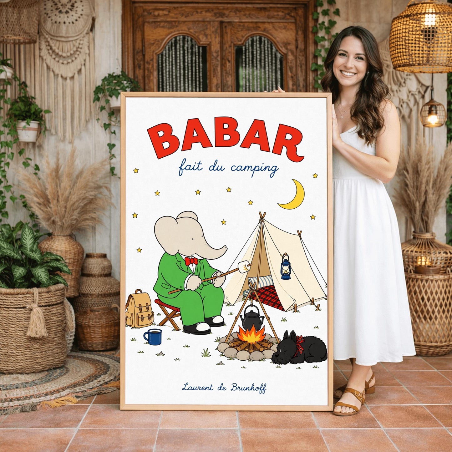 A vertical retro fine art exhibition poster titled "BABAR fait du camping" on a wide cream border. The top "BABAR" text is printed in a bold red font. The illustration shows an elephant in a green suit and red bowtie sitting on a stool by a campfire, toasting a marshmallow next to a white tent under a starry night sky with a yellow crescent moon. A small black dog in a plaid scarf sleeps nearby, and the name "Laurent de Brunhoff" anchors the bottom.