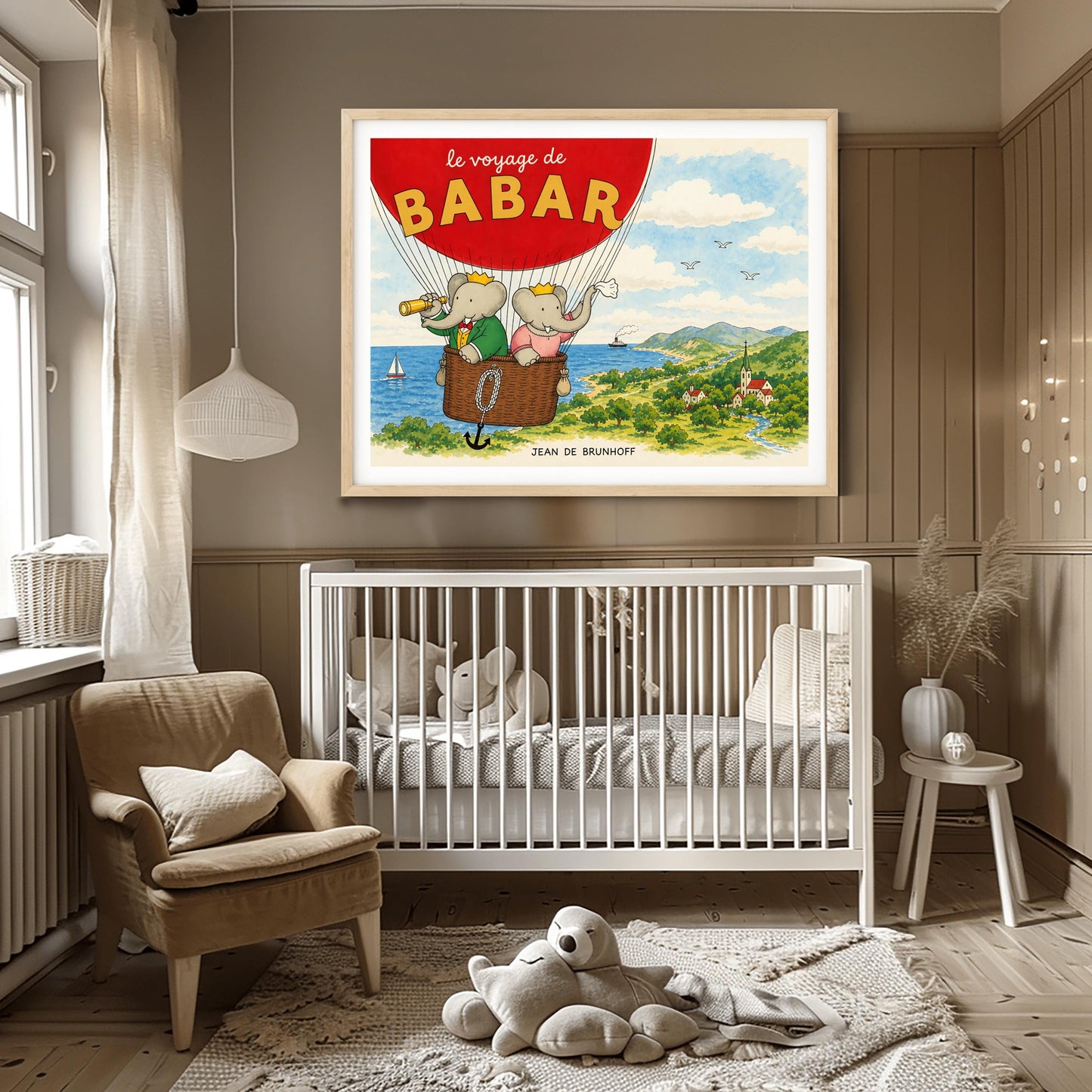 A horizontal watercolor illustration from "Le Voyage de Babar." A large red hot air balloon dominates the top left, with its basket carrying King Babar and Queen Celeste. Babar, in a green suit and crown, looks through a telescope, while Celeste, in a pink dress and crown, waves a white cloth. They are floating over a lush green coastline with a blue ocean, a sailboat, and a small village nestled in a valley with a river and mountains in the distance.