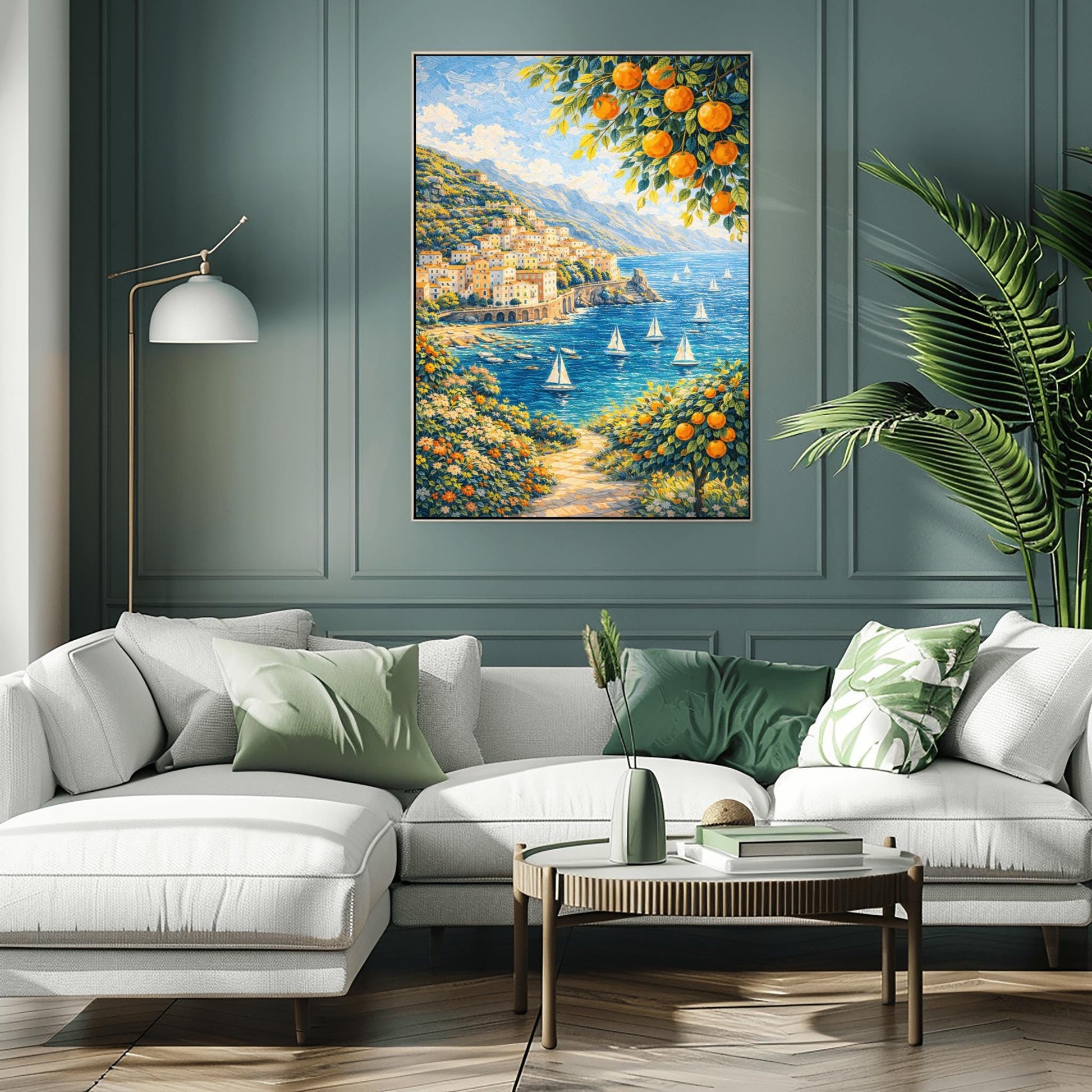 A vertical painterly illustration of a Mediterranean village built into a steep mountainside overlooking a blue sea with many white sailboats. Branches with oranges frame the top and bottom right. A flowered path in the foreground leads toward the water under a bright sky.
