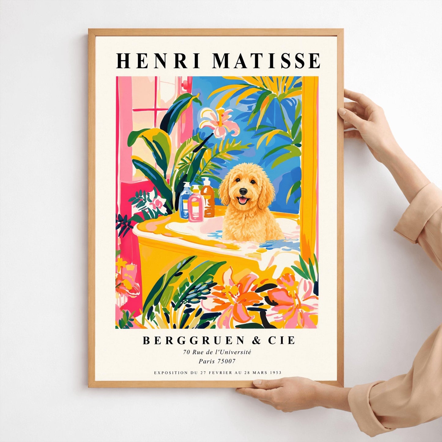 A vertical minimalist fine art exhibition poster in the style of Henri Matisse, shown framed on a wall above a luxury white bathtub. The poster has a wide white border with bold black text reading "HENRI MATISSE" and "BERGGRUEN & CIE". In the center painting, a fluffy golden doodle dog sits happily inside a yellow bathtub surrounded by vibrant pink, blue, and green tropical plants and orange flowers.