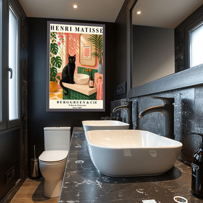 A vertical art print styled as a Henri Matisse exhibition poster. A sleek black cat with bright green eyes sits on a cream-colored bathroom vanity next to a white vessel sink. The bathroom features blush pink walls and emerald green tiles. A gold-framed mirror reflects a Matisse leaf print. Lush green plants and pink flowers frame the scene, and dappled sunlight creates shadows on the wall. The poster has bold black text at the top and bottom with the gallery name Berggruen & Cie.