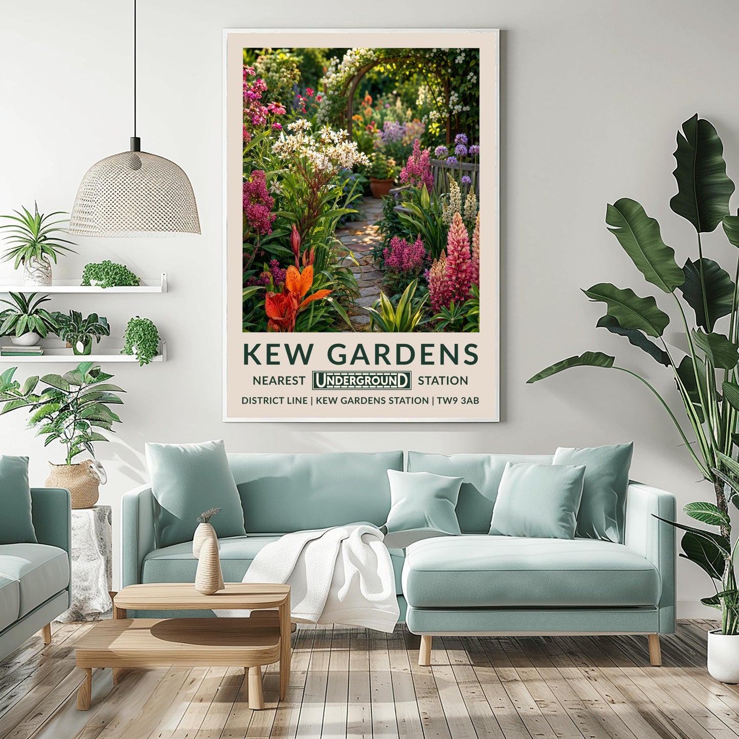 A vertical retro London Underground travel poster for Kew Gardens on a wide cream border. The top image shows a close-up, beautifully detailed illustration of a winding cobblestone garden pathway surrounded by dense flower borders. The foreground features tall pink lupins, a bright orange lily, and clusters of small white flowers. On the right sits a grey wooden bench under purple alliums. The path leads to a wooden archway covered in climbing white roses in the background.