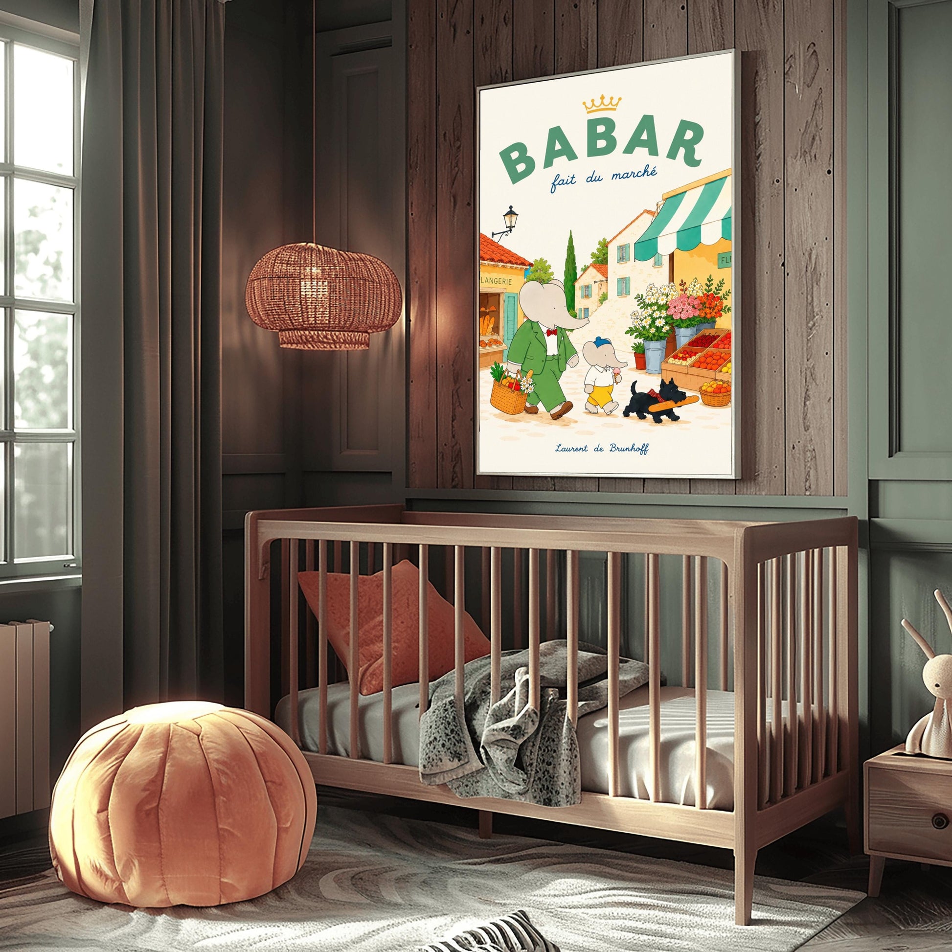 A vertical storybook-style art print of Babar the Elephant walking through a French village street. Babar, in a green suit, carries a basket of groceries. A smaller elephant walks beside him eating a pink ice cream cone, followed by a black dog carrying a baguette. The background features a boulangerie with a yellow facade, a flower stall with pink and white roses, and terracotta-roofed houses under a cream sky. The top reads "BABAR fait du marché" with a gold crown.