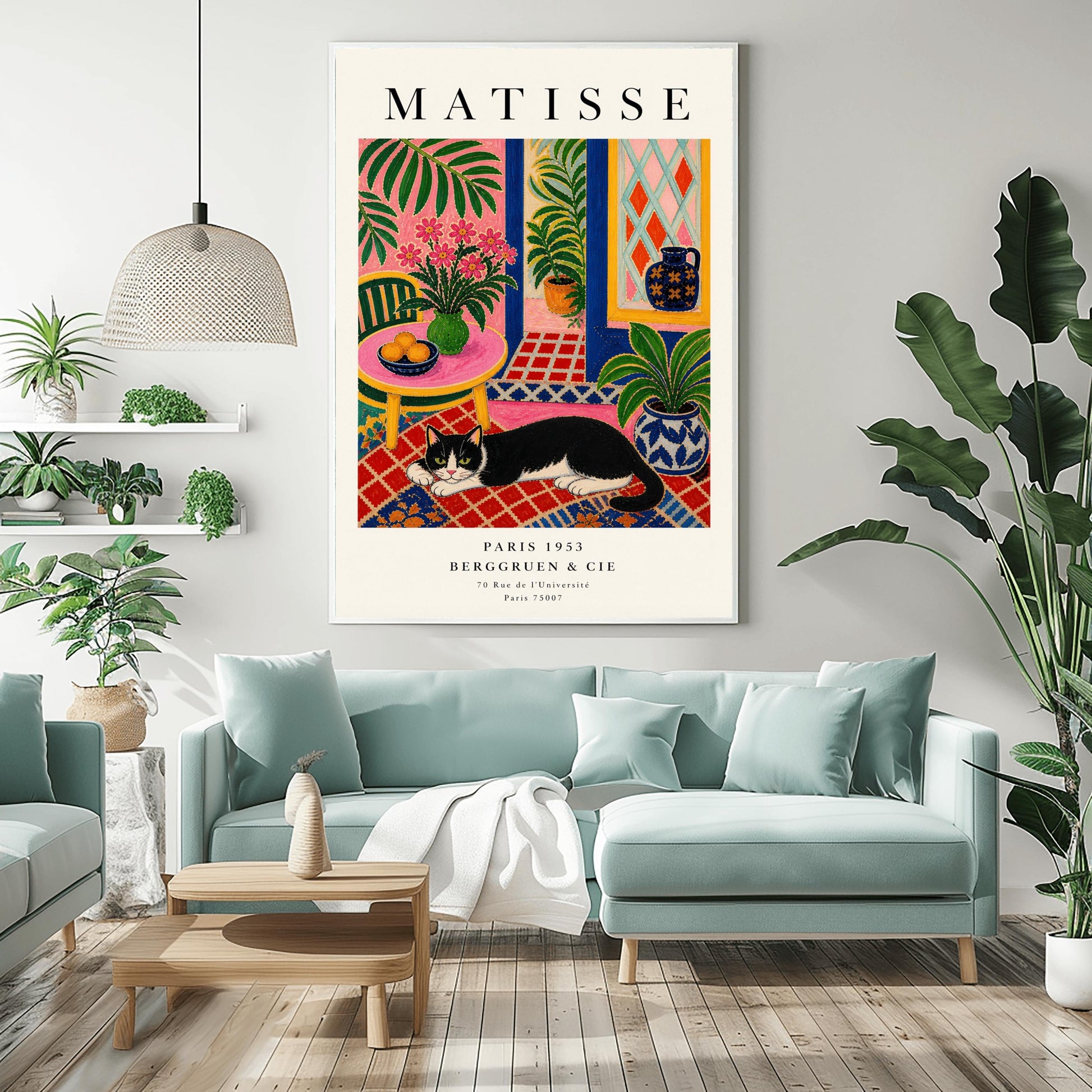 A vertical maximalist art print styled as a Henri Matisse exhibition poster. A black and white tuxedo cat lies across an intricate red, orange, and blue patterned rug. The room features textured bubblegum pink walls and a cobalt blue door frame. To the left, a pink table holds a bowl of oranges and a green vase with pink flowers. To the right, a blue and white floral pot holds a green plant. A diamond-patterned window is visible in the background.