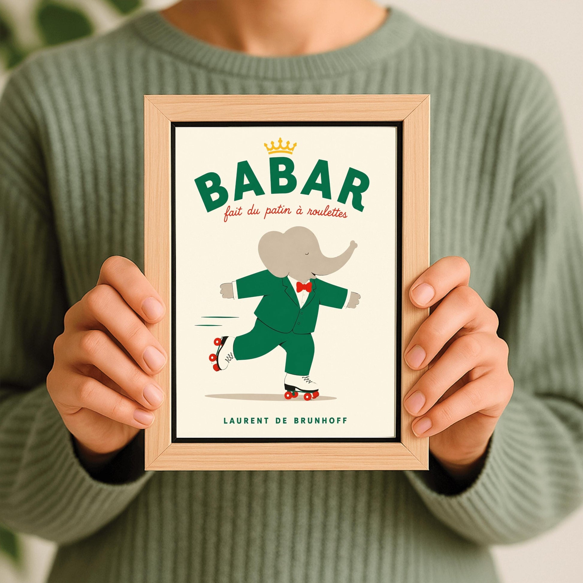 A vertical storybook-style art print of Babar the Elephant roller skating against a cream background. Babar is wearing his signature green suit and red bow tie. He is balanced on white roller skates with red wheels, with one foot lifted behind him. The top of the print features the word "BABAR" in large green letters above the red script text "fait du patin à roulettes" and a small gold crown. The name "LAURENT DE BRUNHOFF" is printed at the bottom.