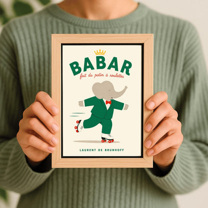A vertical storybook-style art print of Babar the Elephant roller skating against a cream background. Babar is wearing his signature green suit and red bow tie. He is balanced on white roller skates with red wheels, with one foot lifted behind him. The top of the print features the word "BABAR" in large green letters above the red script text "fait du patin à roulettes" and a small gold crown. The name "LAURENT DE BRUNHOFF" is printed at the bottom.