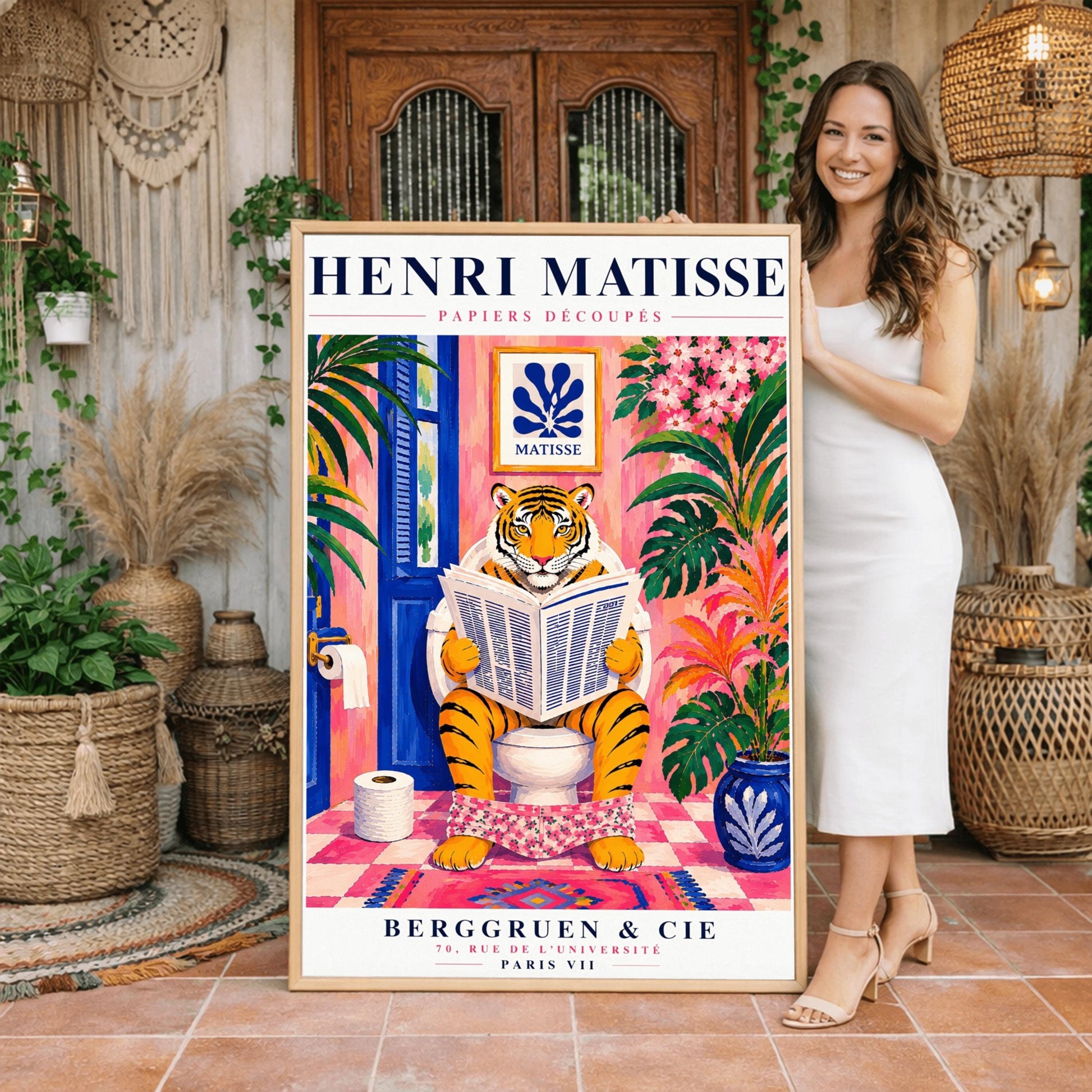 A vertical art print styled as a Henri Matisse exhibition poster. In the center, a tiger sits on a toilet in a pink bathroom, reading a newspaper with pink floral pants at its ankles. The room is decorated with lush tropical plants, a blue door, and a small Matisse-style blue cutout art piece on the wall. The text "HENRI MATISSE" is at the top, and "BERGGRUEN & CIE" is at the bottom.