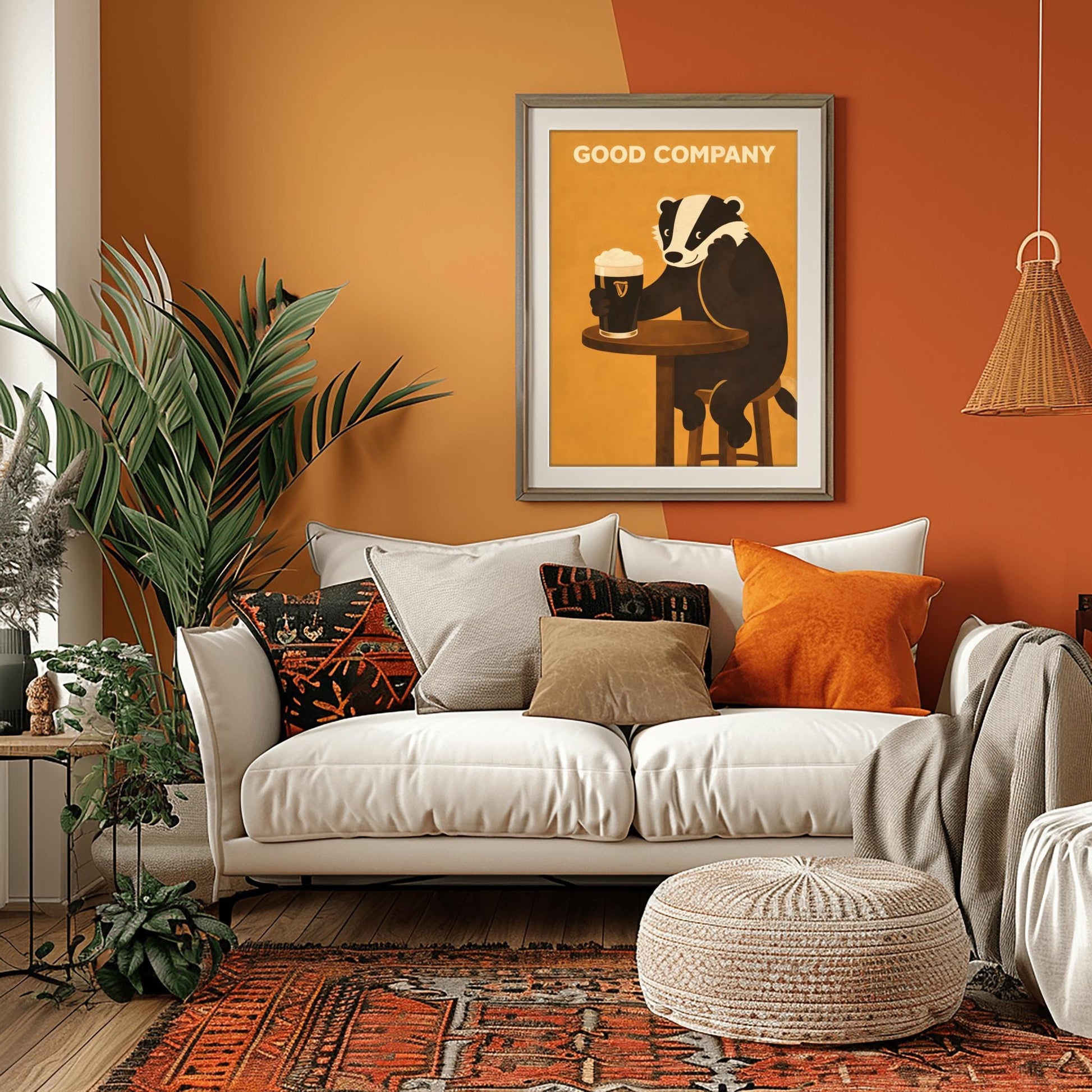 A vertical modern illustration of a cute black and white badger sitting at a round wooden bar table. The badger is leaning on one arm and holding a pint of Guinness with the other. The text "GOOD COMPANY" is written in bold at the top against a warm amber background.