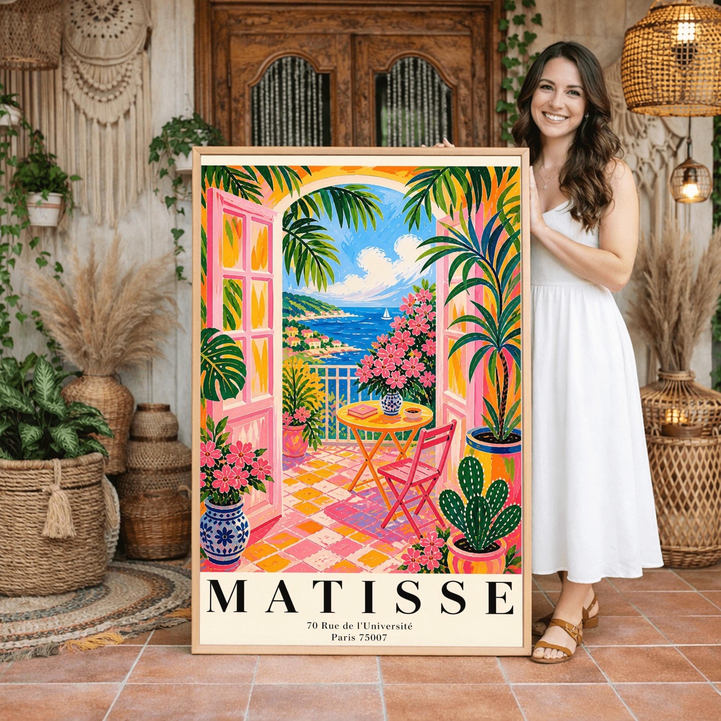 A vertical maximalist art print styled as a Henri Matisse exhibition poster. The scene features a vibrant balcony with pink-framed glass doors open to a view of the blue Mediterranean sea and a coastal town. The balcony has pink and yellow checkered tiles, a yellow round table with a pink chair, and is filled with tropical plants and pink flowers in blue and white vases. A sailboat is visible on the water under a bright blue sky with white clouds.