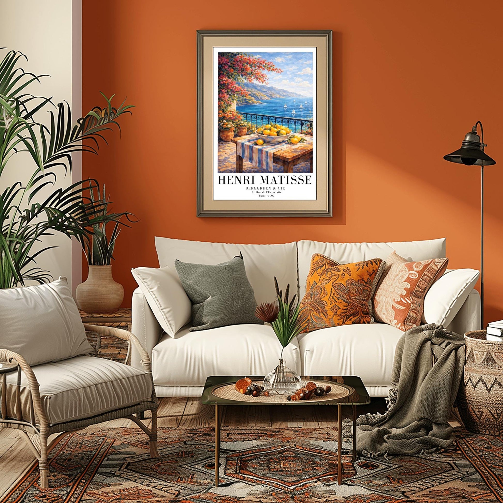 A vertical painterly illustration of a stone terrace with a black iron railing. A pink bougainvillea tree hangs from the top left over a wooden table with a bowl of oranges and lemons. Beyond the railing is a blue sea with white sailboats and a distant mountainous coastline.