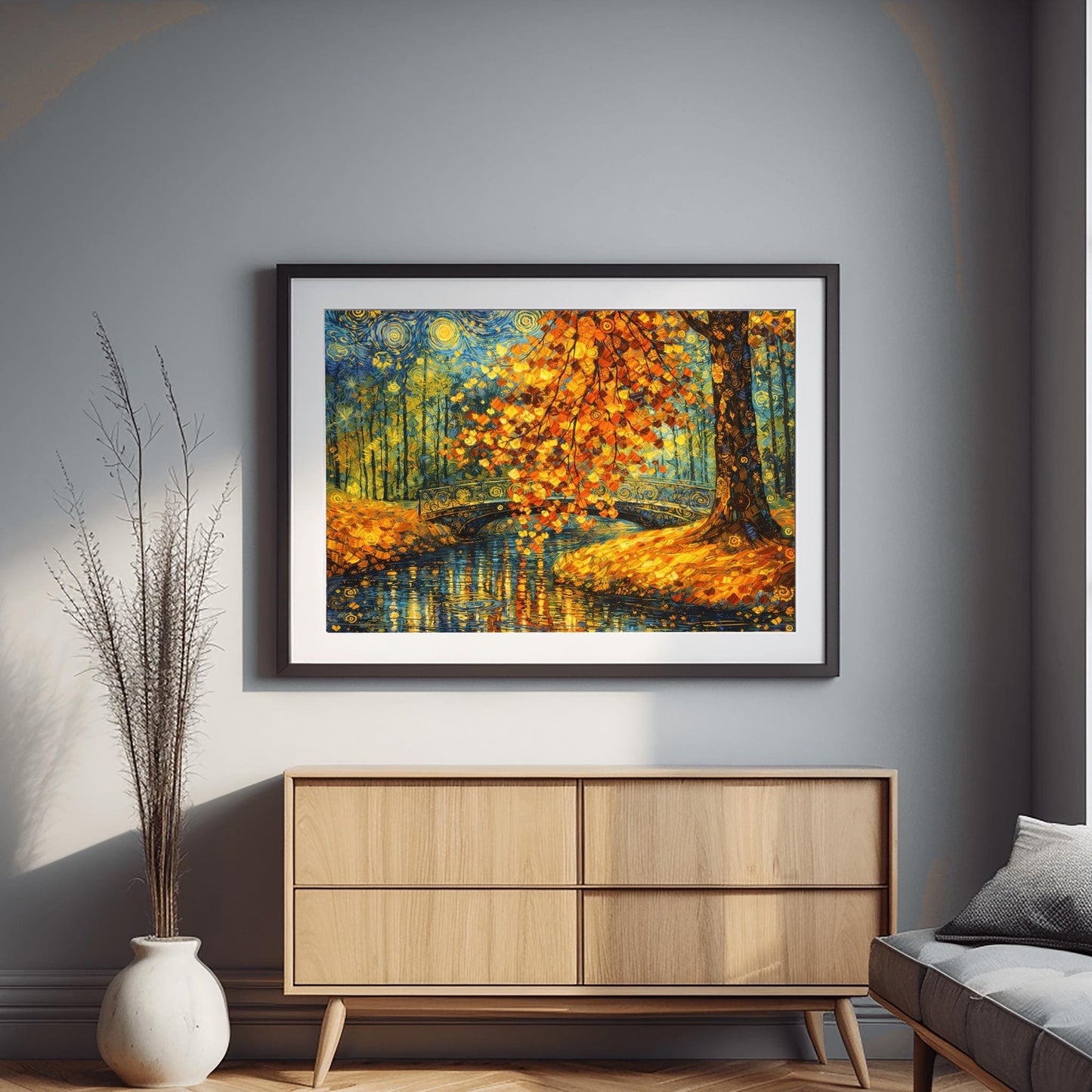 A horizontal landscape art print in the style of Gustav Klimt. A large tree with shimmering golden and orange mosaic-style leaves hangs over a dark blue pond. An ornate black bridge with golden spiral patterns crosses the water in the background. The sky is filled with stylized yellow swirls and stars. The ground is covered in golden leaves, and the entire scene is rich with decorative textures and vibrant metallic tones.