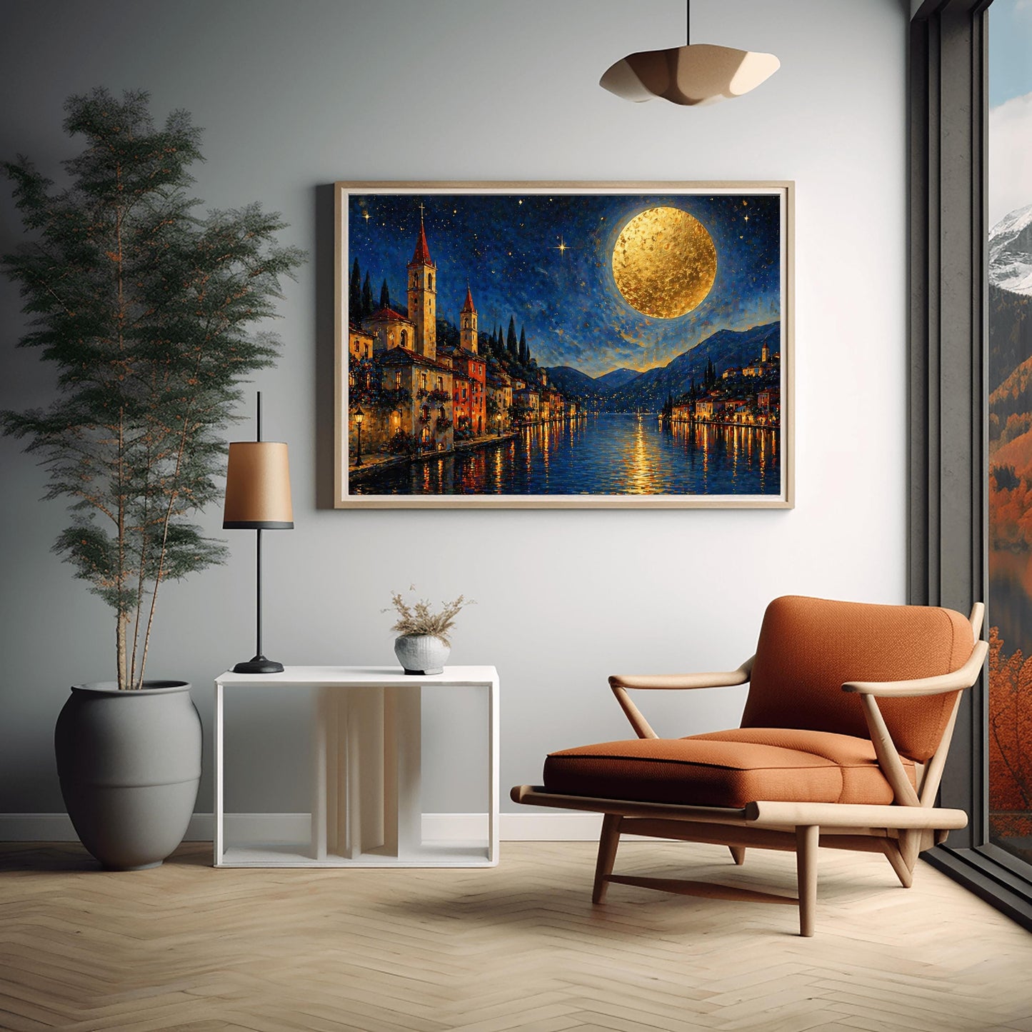 A horizontal art print in a decorative mosaic style inspired by Gustav Klimt. A charming lakeside village with warm-lit windows and tall church spires sits along the edge of dark blue water. A massive, glowing golden moon with heavy texture hangs in a starry night sky. The light from the moon and the town reflects in long, shimmering streaks on the water. The mountains in the distance are shaded in soft blues and purples.
