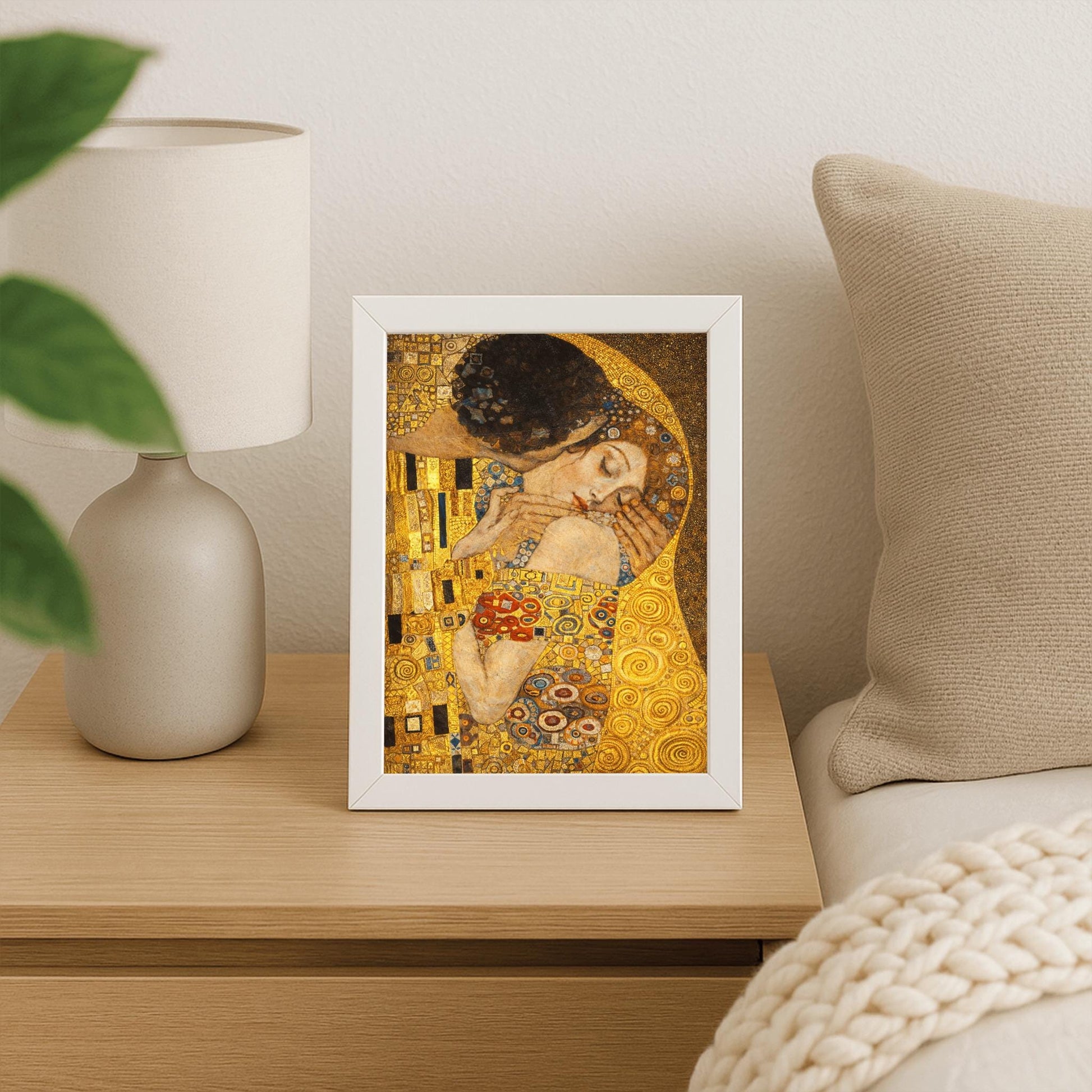 A vertical fine art print in the style of Gustav Klimt's "The Kiss." An embracing couple is centered, their bodies merged under a single, ornate golden cloak filled with geometric patterns like black and white rectangles and colorful spirals. The woman’s face is turned upward with eyes closed in a peaceful expression. The background is a shimmering, textured gold field, creating a radiant and romantic Art Nouveau atmosphere.
