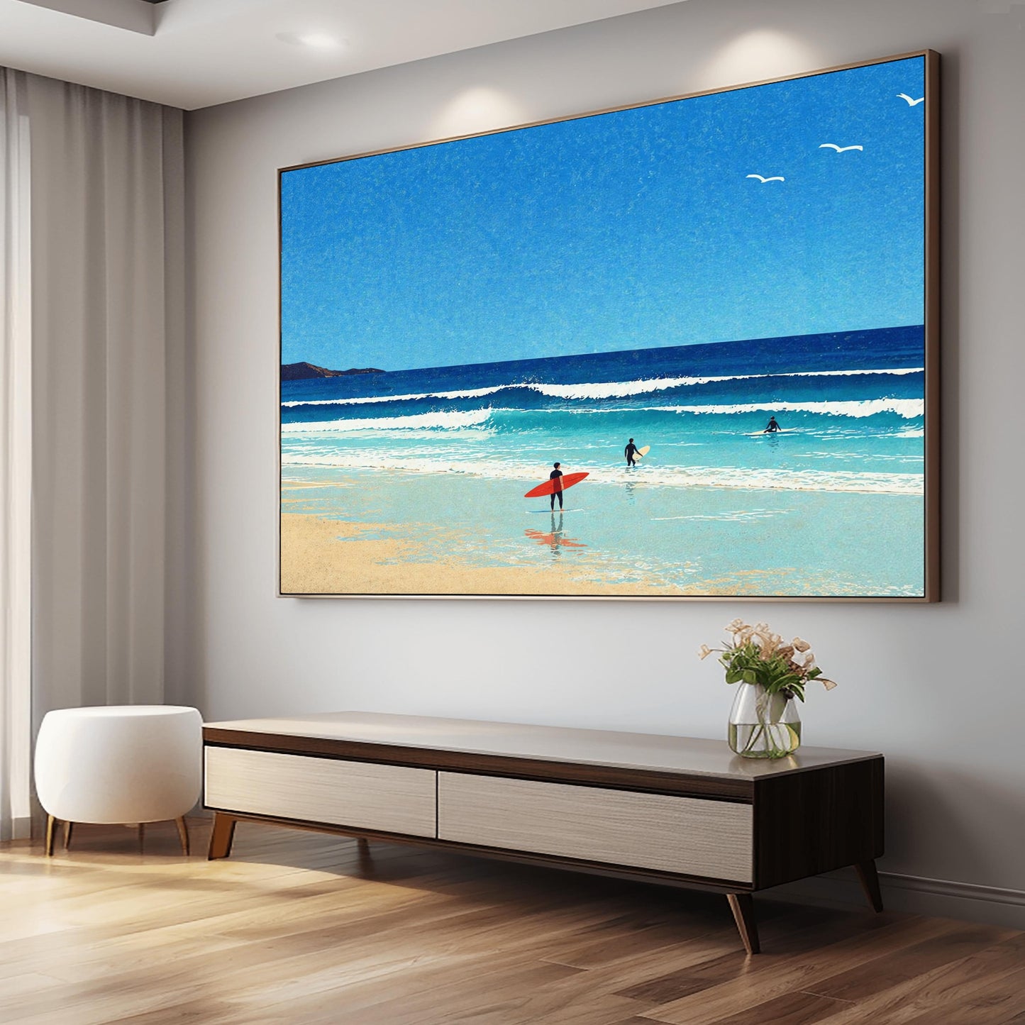 A horizontal minimalist art print of a bright beach day. A vast blue sky with three small white birds in flight sits above a turquoise ocean with gentle white waves. In the foreground, a sandy beach meets the water. A lone surfer in a black wetsuit holds a bright red surfboard on the shore, while two other surfers are further out in the water. A dark cliff is visible on the far left horizon. The style is clean and graphic with a subtle paper texture.