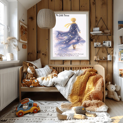 A vertical illustration poster titled "The Little Prince" in elegant script. A young boy with golden hair and a yellow scarf is seen from behind, walking into a white, misty background. He wears a long blue coat that looks like a starry galaxy, filled with glowing stars and purple nebulae. At the bottom, a quote about stars being guides for travelers is written in a simple black font.