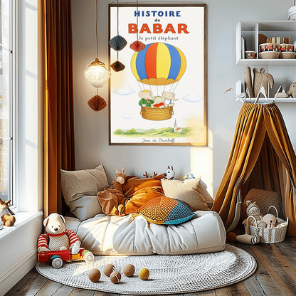 A vertical vintage-style storybook poster on an off-white background titled "HISTOIRE de BABAR le petit éléphant" in bold blue and orange font. The illustration features a large hot air balloon with yellow, blue, and orange stripes floating in a sky with soft clouds. Inside the wicker basket, three cartoon elephants ride together. On the left, King Babar wears a green suit and crown while pointing ahead. The other two young elephants wear red and white shirts.