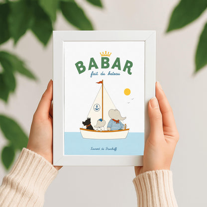 A vertical storybook-style art print of Babar the Elephant sailing a boat against a white background. Babar, wearing a blue and white striped shirt and a red neckerchief, sits in a white boat with a smaller elephant and a black dog. The sailboat has a white sail with a blue anchor logo and a red flag on top. A yellow sun and two small birds are in the sky. The top reads "BABAR fait du bateau" with a gold crown.