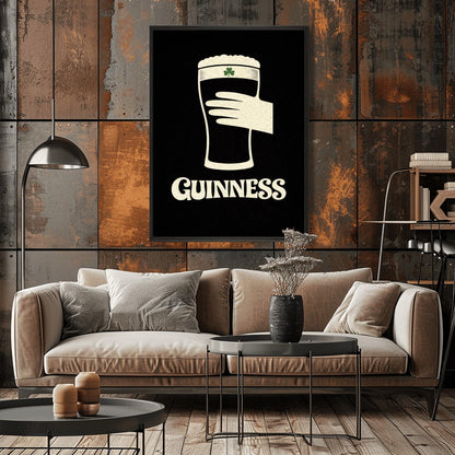 A vertical minimalist graphic design on a textured black background. A cream-colored hand is shown holding a pint of Guinness stout, with the glass itself created out of negative space. A small green shamrock is on the foam. The word "GUINNESS" is in cream text at the bottom.